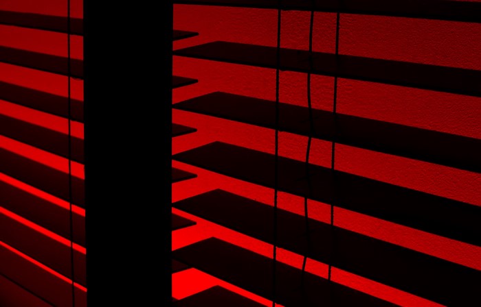 Red blinds with dark shadows and light patterns