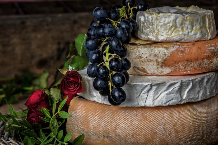 Still life with cheese, grapes, and roses