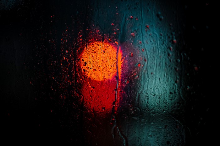 Blurred orange light through water on glass
