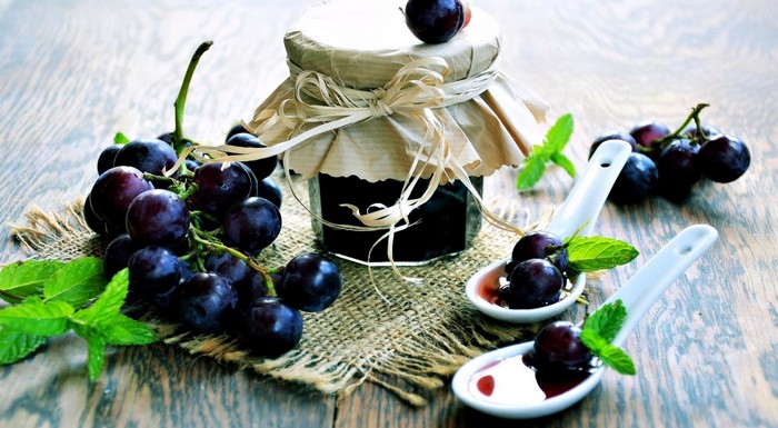 Grape jam in a jar with fresh grapes and mint