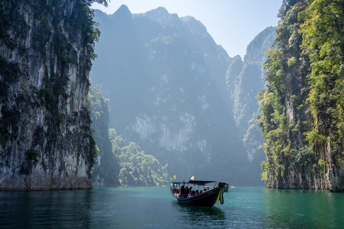 Boat on a lake surrounded by limestone cliffs