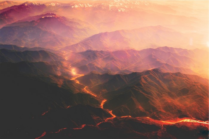 Aerial view of mountains with lava flow at sunset