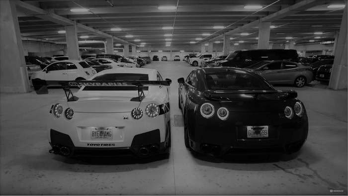 Two Nissan GT-R cars in a parking garage