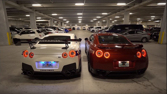Two Nissan GT-R cars in a parking garage
