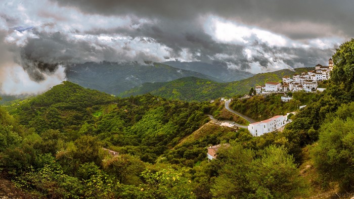 White village on a green mountainside in Spain