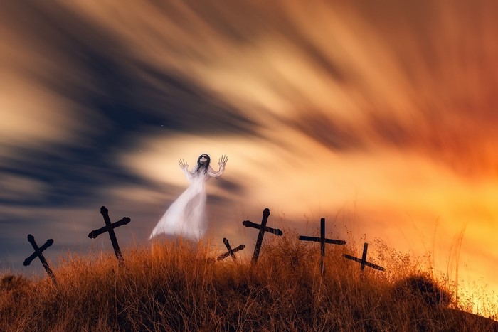 Ghostly figure in a graveyard with a dramatic sky