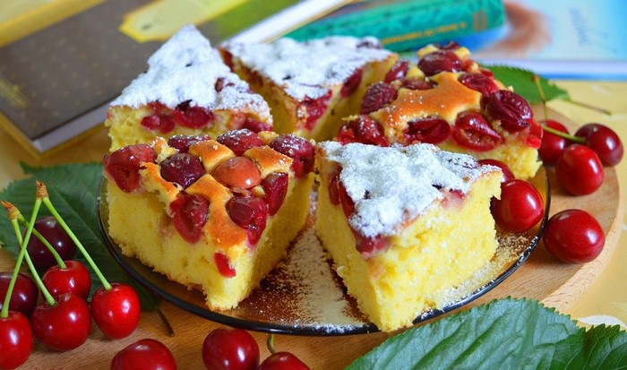 Cherry cake slices with powdered sugar and fresh cherries