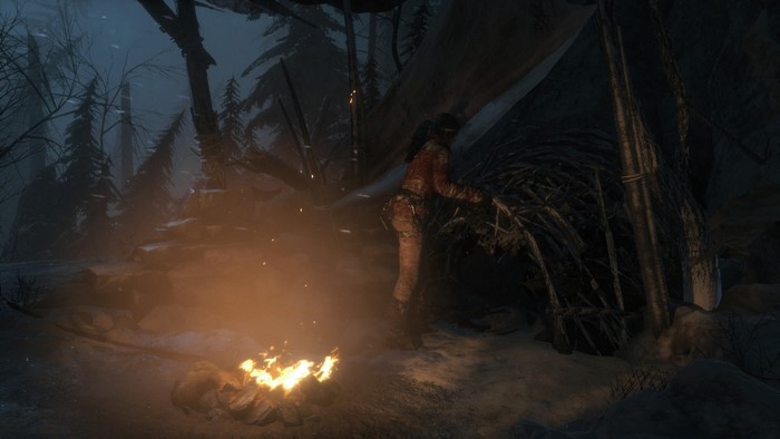 Lara Croft in a winter shelter with a campfire in Rise of the Tomb Raider