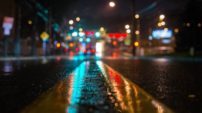 Wet city street at night with traffic light reflections