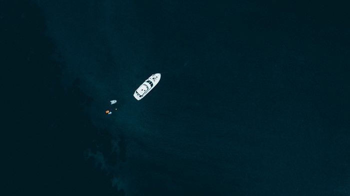 Aerial view of boats on dark blue sea