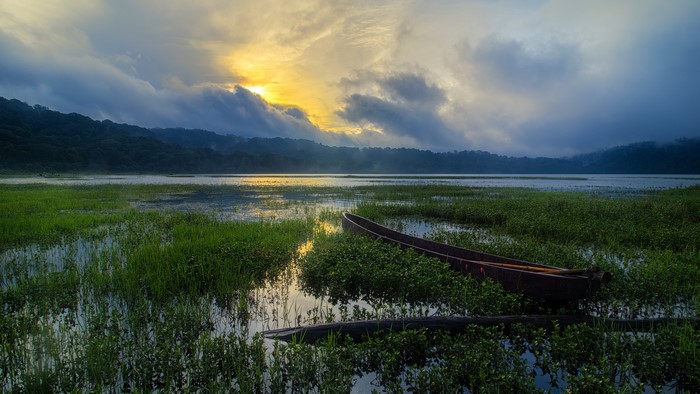 4K boat on a misty lake at sunrise