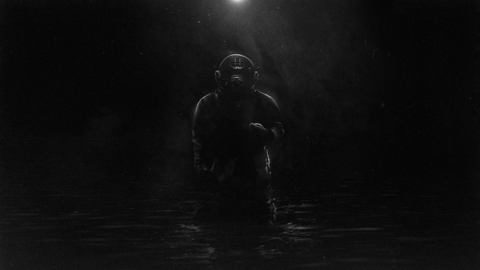 Man in diving suit standing in dark water