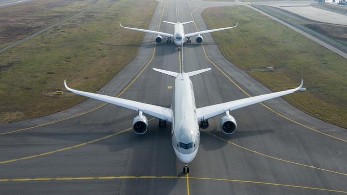 Two Qatar Airways Airbus A350s on a runway