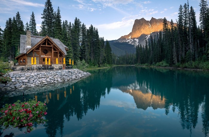 Log cabin by Emerald Lake with mountain reflection