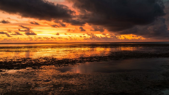 Sunset over the ocean with dark clouds