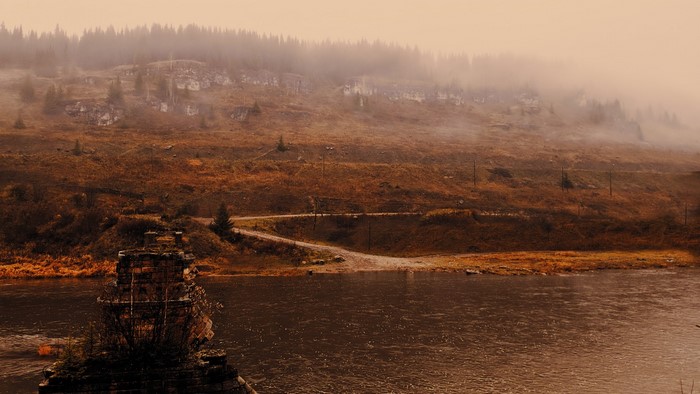 Misty river landscape with ruins and forest