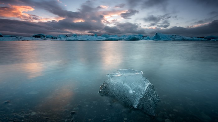 Icebergs floating in water at sunset