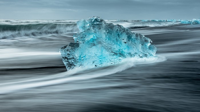 4K ice on black sand beach with waves