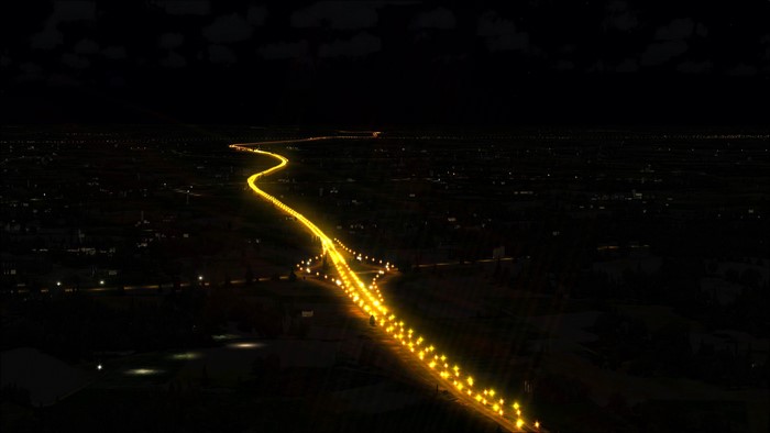 Winding highway illuminated by streetlights at night