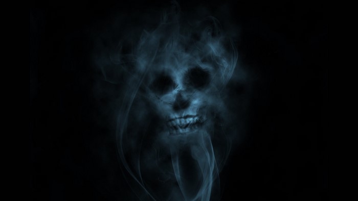Skull formed from blue smoke on a black background