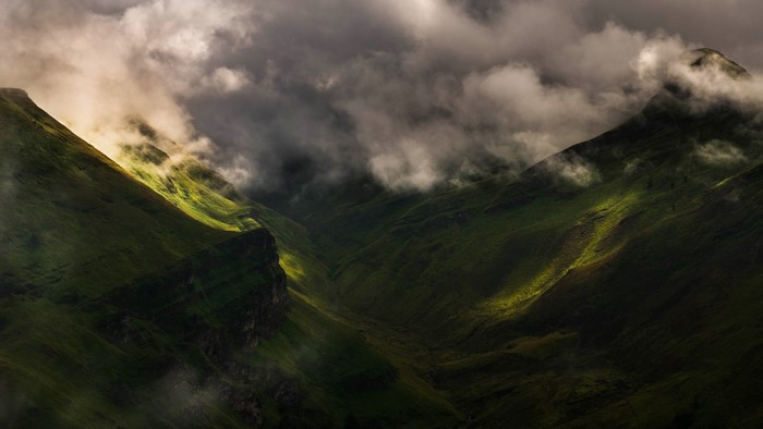 Dark mountains with clouds and sunlight