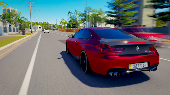 Red BMW M Performance car driving on a road