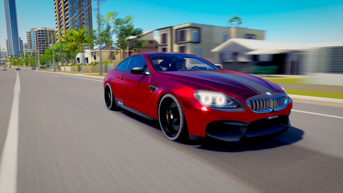 Red BMW M6 Coupe driving on a sunny road