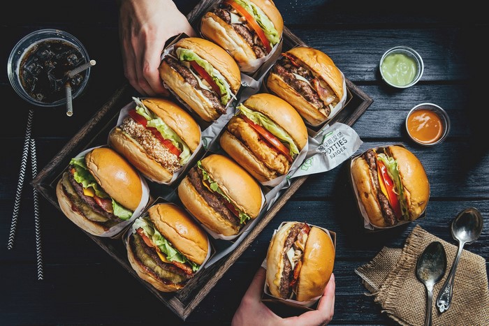 Tray of assorted burgers with soda and dipping sauces