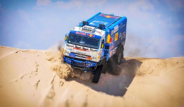 Kamaz truck racing through desert dunes