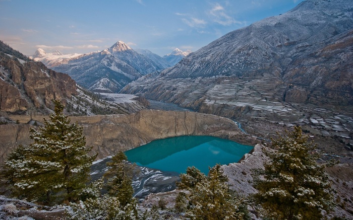 Turquoise lake in a mountain valley with snow-capped peaks