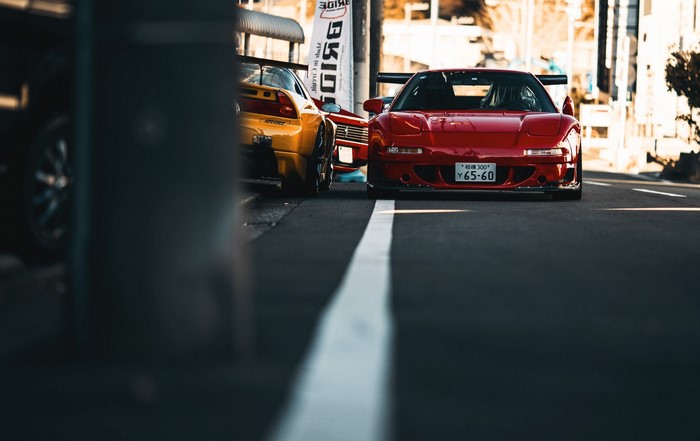 Red and yellow Honda NSX sports cars parked on street