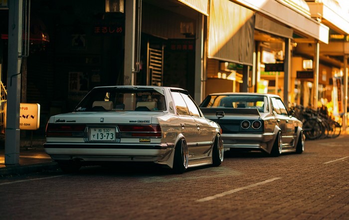 Toyota Chaser and Nissan Skyline GT-R parked on street at sunset