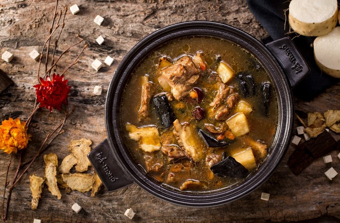 Herbal meat soup in a pot with ingredients