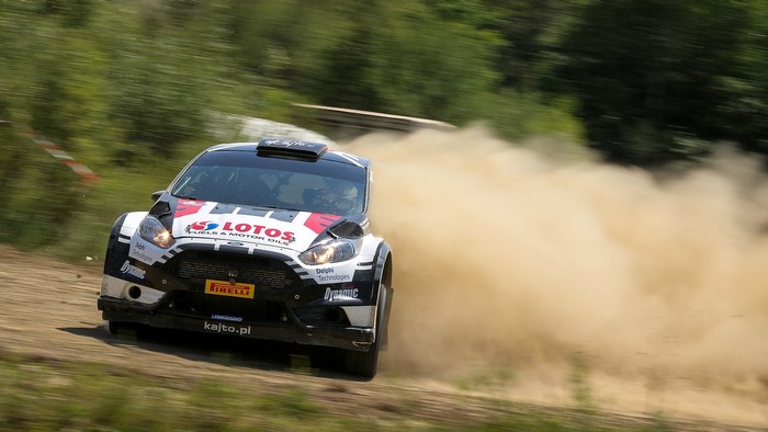 Ford Fiesta WRC rally car kicking up dust on a gravel road