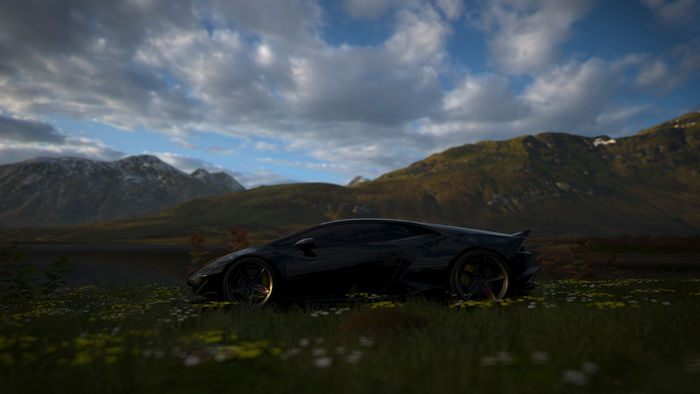 Black Lamborghini in a field with mountains