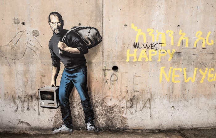 Steve Jobs street art by Banksy on concrete wall