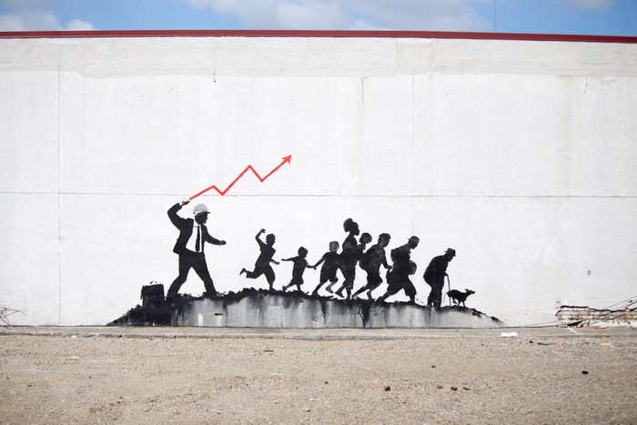 Graffiti of a man leading people with a rising graph
