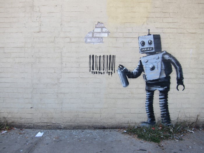 Robot spray painting a barcode on a brick wall