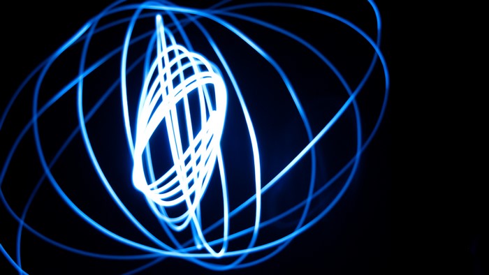 Abstract blue light trails on black background