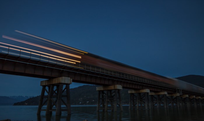 Train light trails on bridge at dusk