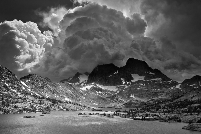 Monochrome mountain landscape with lake and storm clouds