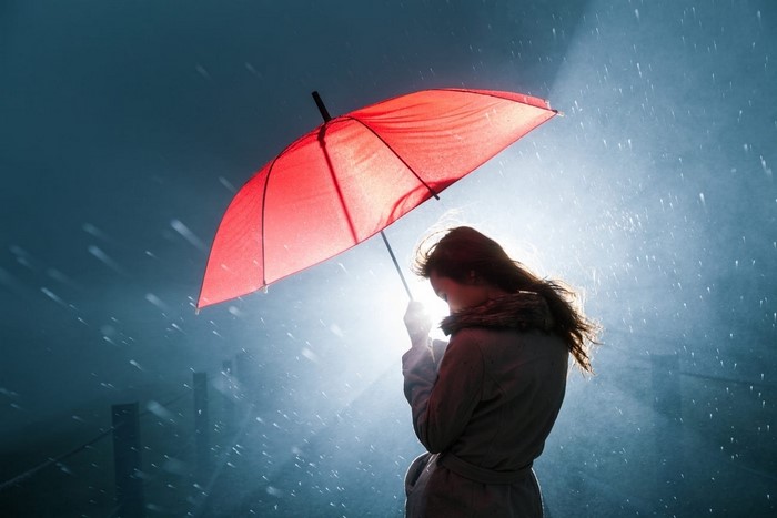 Woman with red umbrella in the rain