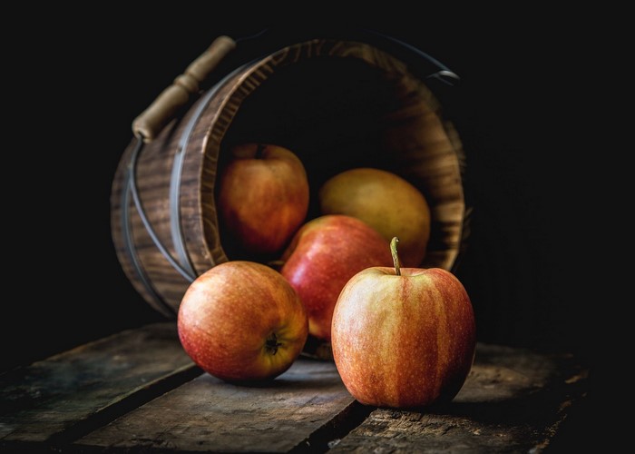 Apples in a wooden bucket on a table