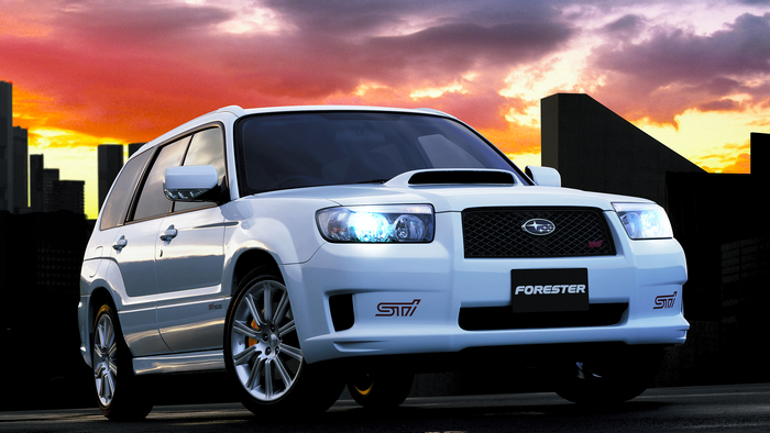 White Subaru Forester STI with city skyline at sunset