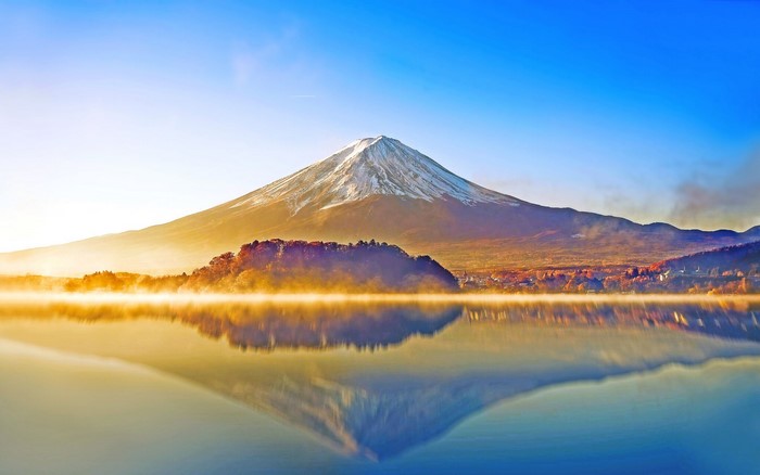 Mount Fuji reflected in a misty lake at sunrise