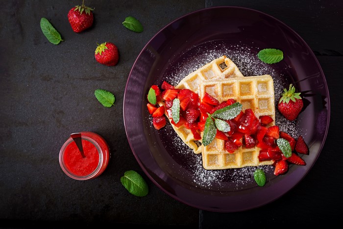 Waffles with strawberries and mint on a plate