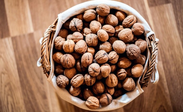 Basket of walnuts on a wooden surface