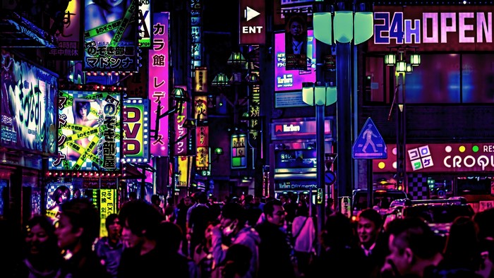 Night street with neon signs and crowds