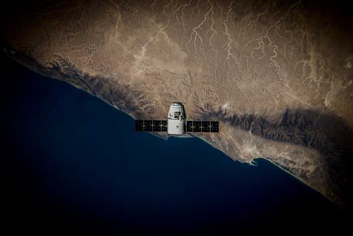 SpaceX Dragon spacecraft over Earth's coast