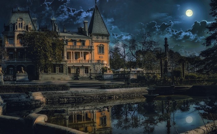Haunted mansion by the lake under the full moon